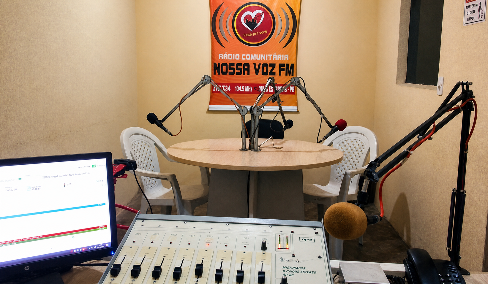 Estúdio da Rádio Comunitária Nossa Voz FM com mesa de som e microfones